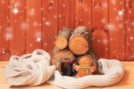 Christmas composition. Glasses of mulled wine, gingerbread man, scarf and pile of firewood. View...