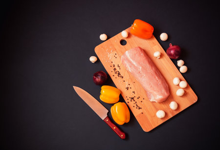 Fresh pork fillet on cutting board on darkの写真素材
