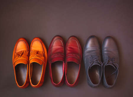 Stylish male multi colored leather shoes on dark background. Top view, copy space.の写真素材