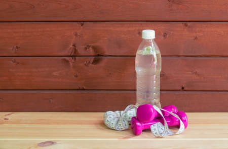 Dumbbells, bottle of water and measure tape. View with copy space.の写真素材