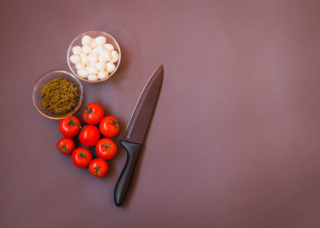 Tomatoes, pesto sauce and mozzarella cheese for making caprese salad  on gray background. Top view,...