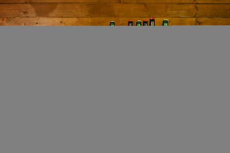 Mugs, glasses and bottles with beer stand on wooden shelves. View with copy space.の写真素材