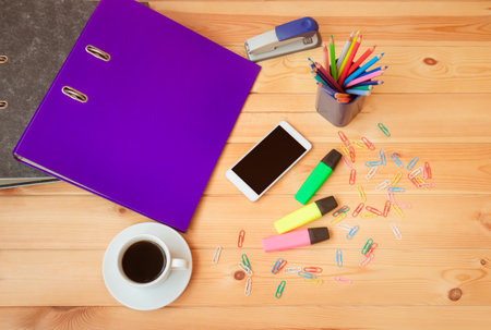 Workplace with folders, smartphone, coffee cup and office supplies. Top view, copy space.の写真素材