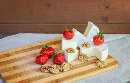Camembert cheese with fresh ripe strawberries and walnuts.の写真素材