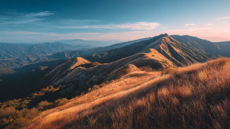 Warm sunlight illuminates a mountain ridge landscape at sunrise.の素材