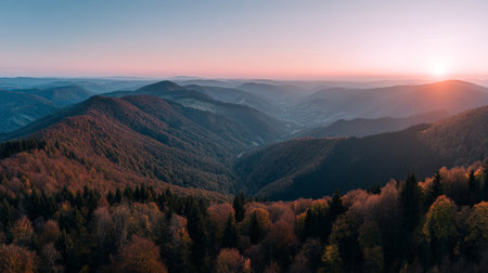 Majestic mountain landscape at dawn with forest ridges and vibrant colors.の素材