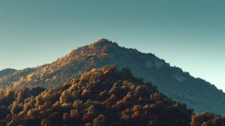 Majestic Mountain Peak Bathed in Golden Light Against a Serene Blue Skyの素材