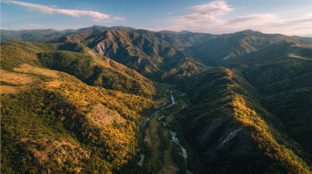 Breathtaking aerial view featuring golden trees, a winding river, and majestic mountain peaks.の素材
