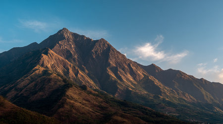 Majestic Mountain Peaks Bathed in Warm Light Against a Clear Blue Skyの素材