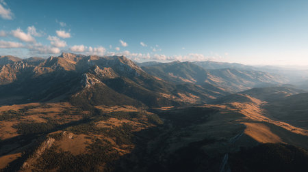 Mountain Range Scenic Vista Underneath a Pale Blue Sky with Light Cloudsの素材