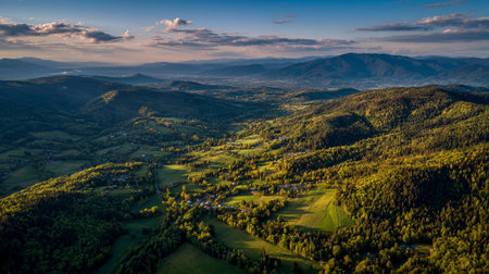 Rolling Hills and Valley Landscape with Distant Mountains Under a Blue Skyの素材