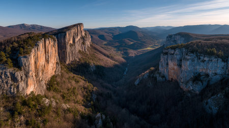 Breathtaking aerial view of steep rock formations in a valley during daytime.の素材