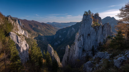 Mountainous Landscape with Jagged Peaks and Autumn Foliage Under a Bright Blue Skyの素材