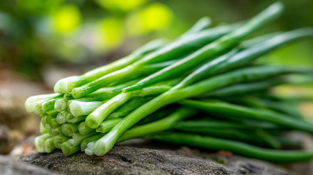 Freshly harvested green onions piled gracefully on a textured stone surfaceの素材