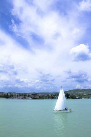 Sailing ship in the lake Balaton, under the blue sky, before the beach.の写真素材