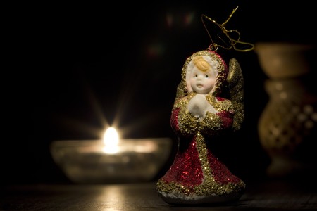 Red and golden christmas angel with candles in the night の写真素材