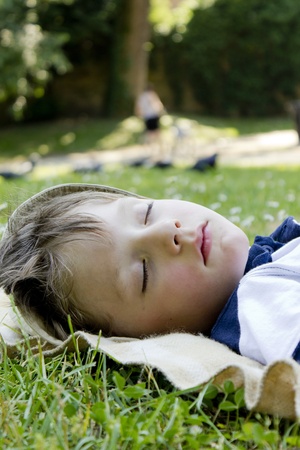 Young boy sleeping in the green grass.の写真素材