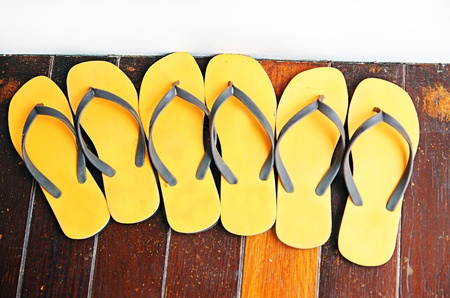 SIX FEET : Yellow Six Sandals or Six Slippers, That is on the wood board in the summer time.の写真素材