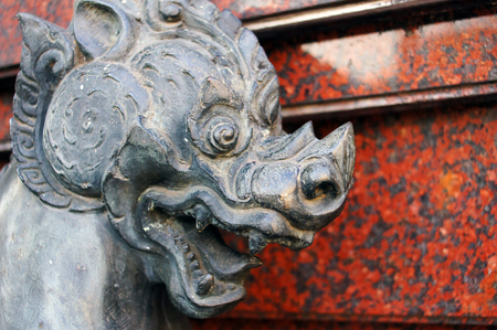 The Stone Head Myth Singha on red stone shade backgroud in Thailandの写真素材