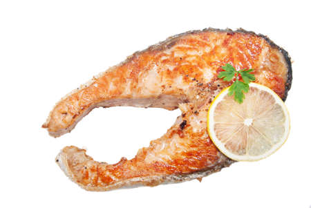 Appetizing salmon steak with lemon slice on a frying panの写真素材