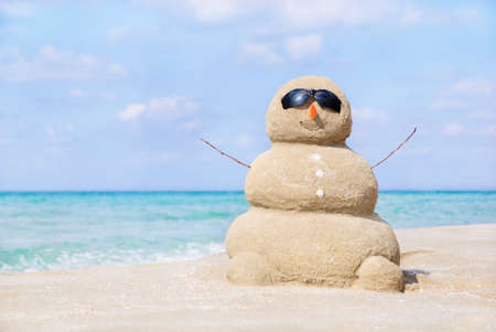 Smiling sandy happy man in sunglasses on the sea beach against blue cloudy summer sky - travel conceptの写真素材