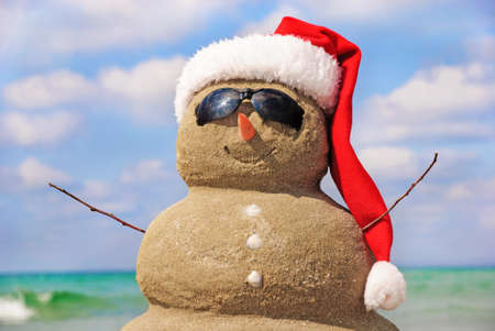 Snowman made out of sand against the sky. Holiday concept can be used for New Year and Christmas Cardsの写真素材