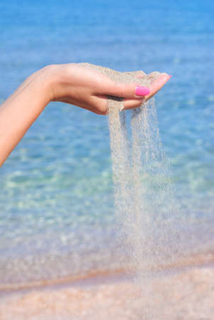 sand pour away through the hands against sea, instability conceptの写真素材