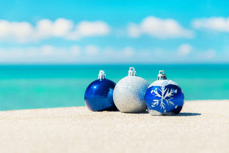 Christmas tree decorations on sea beach sand - winter holidays in hot countries conceptの写真素材