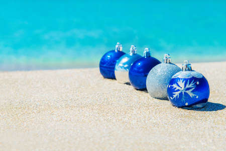 Christmas tree decorations on sea beach sand - winter holidays in hot countries conceptの写真素材
