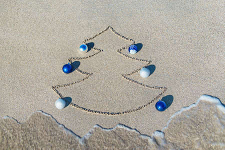 Christmas tree contour with decorations, star and wave on the beach - holiday vacation conceptの写真素材