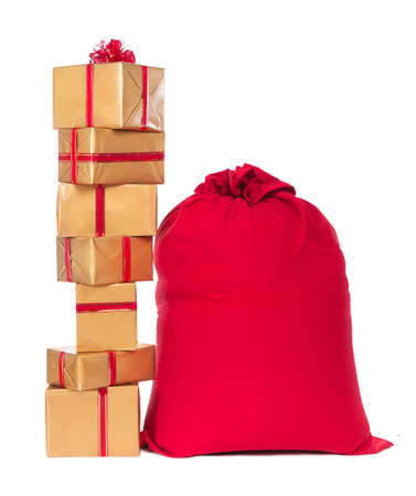 Red Christmas sack and pile of golden wrapped gift boxes with red ribbons and bows, isolated on a white background.
の写真素材