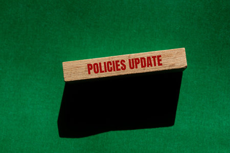 Policies update message written on wooden block with green background. Conceptual policies update symbol. Copy space.の写真素材
