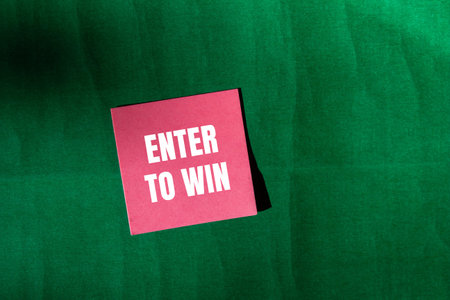 Enter to win message written on pink paper with green background. Conceptual enter to win symbol....