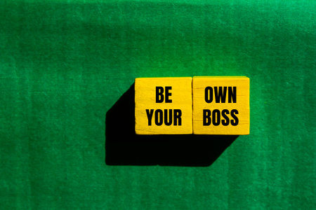 Be your own boss message written on yellow wooden cubes with green background. Conceptual be your own boss symbol. Copy space.の写真素材