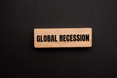 Global recession message written on single wooden block with black background. Conceptual global...