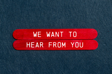 We want to hear from you message written on red wooden sticks with gray felt background. Conceptual we want to hear from you symbol. Copy space.の写真素材