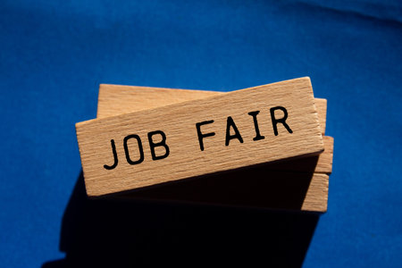 Job fair message written on wooden blocks on blue background. Conceptual job fair symbol. Copy space.の写真素材
