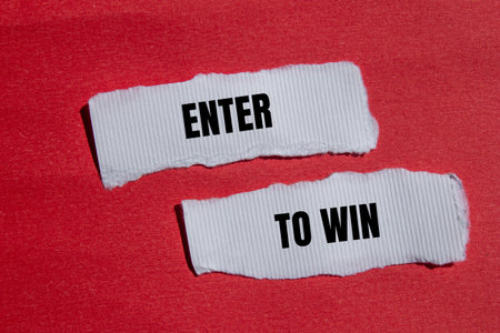 Enter to win message written on ripped torn white paper with red background. Conceptual enter to...