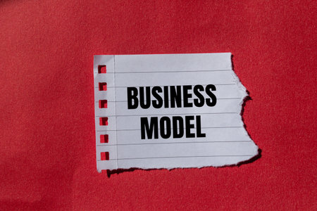 Business model message written on torn torn paper with red background. Conceptual business model symbol. Copy space.の写真素材