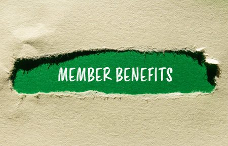 Member benefits message written on ripped torn paper with green background. Conceptual member benefits symbol. Copy space.の写真素材