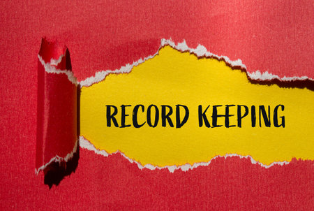 Record keeping message written on ripped torn red paper with yellow background. Conceptual record keeping symbol. Copy space.の写真素材