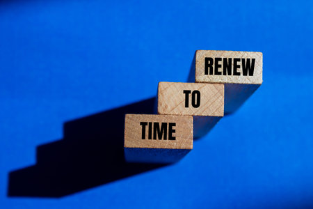 Time to renew message written on wooden blocks with blue background. Conceptual time to renew symbol. Copy space.の写真素材