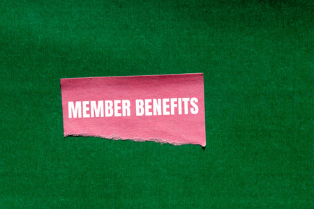 Member benefits message written on ripped torn pink paper piece on green background. Conceptual member benefits symbol. Copy space.の写真素材