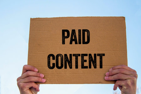 Paid content message written on cardboard sign. Conceptual paid content symbol. Copy space.