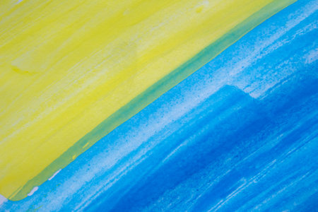 Bright and textured watercolor background in vibrant shades of yellow and blue, featuring soft brush strokes and subtle gradientsの写真素材