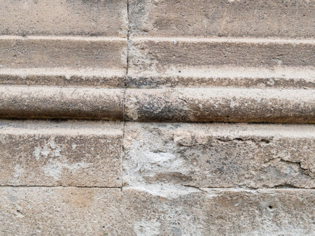 Weathered stone wall texture with cracked cement detailsの写真素材