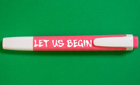 Let us begin message written on pink marker pen on green background. Conceptual let us begin symbol....