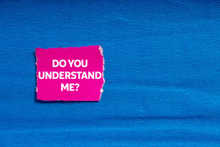 Do you understand me message written on ripped torn pink paper on blue background. Conceptual do you...