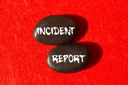 Incident report message written on black stones on red background. Conceptual incident report symbol. Copy space.の写真素材