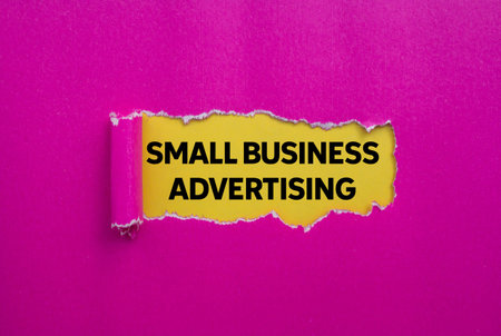 Small business advertising message written on ripped torn pink paper on yellow background. Conceptual small business advertising symbol. Copy space.